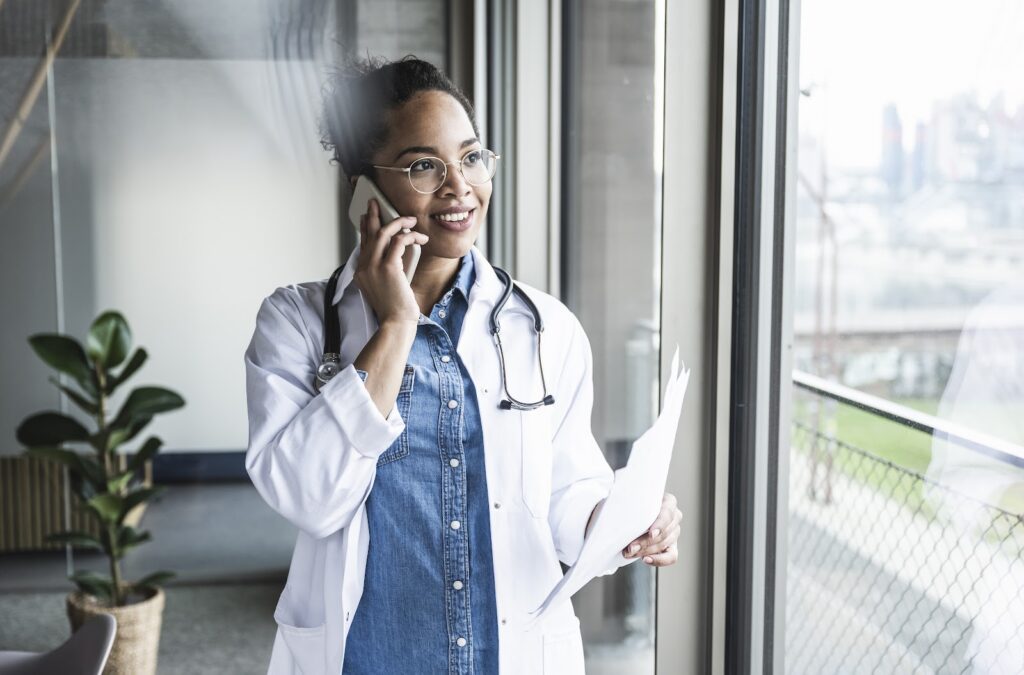 A female physician assistant consults with a patient by phone.