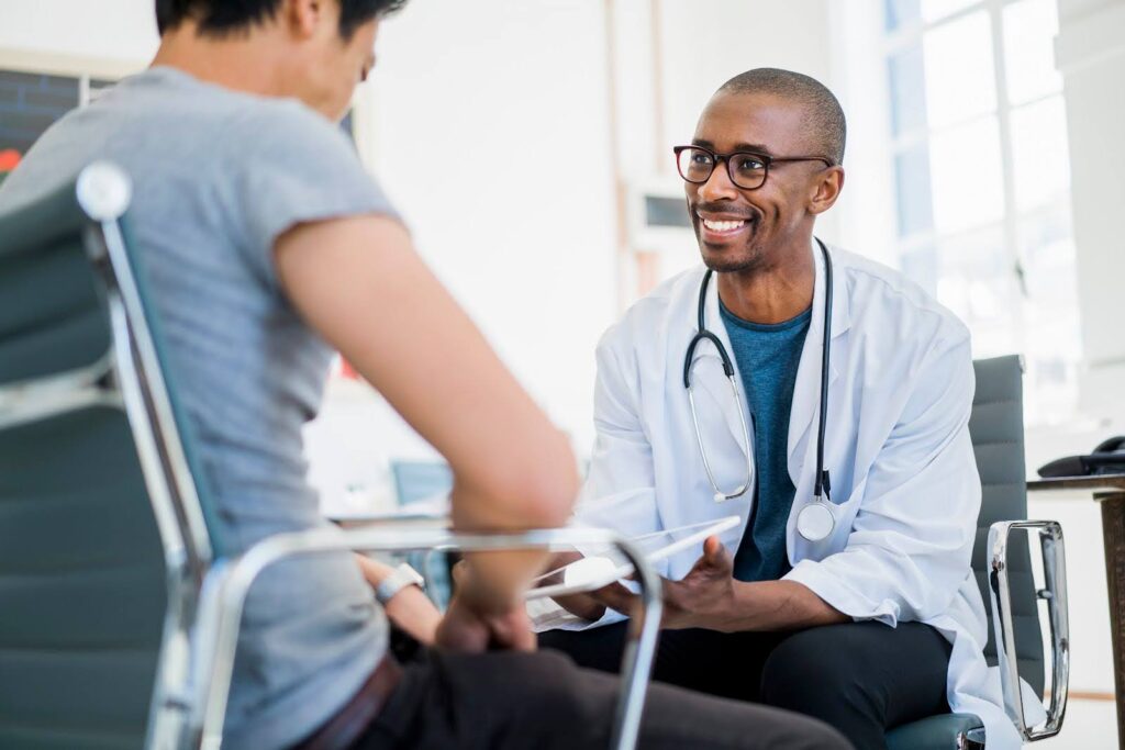 A smiling physician assistant consults with a patient.