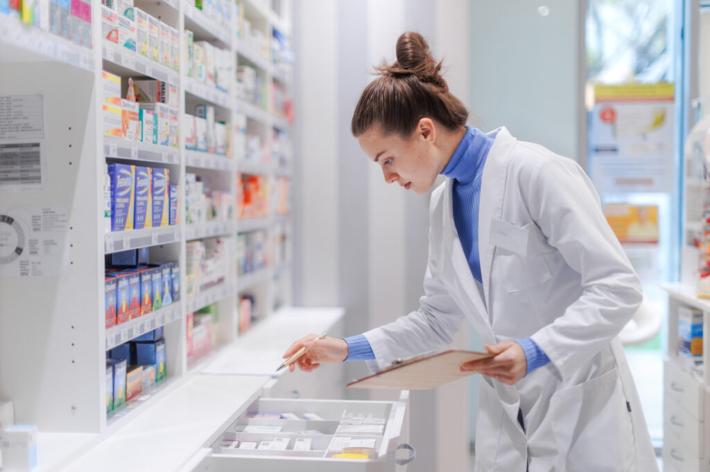 A pharmacy informaticist collecting information on various medications within a pharmacy.