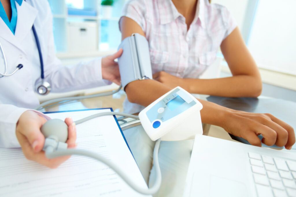 A close up of a physician assistant taking a patient’s blood pressure reading.